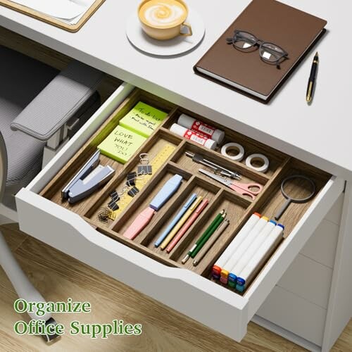 Open desk drawer with neatly organized office supplies.