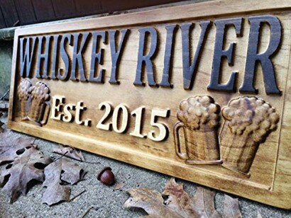 Wooden sign with 'Whiskey River Est. 2015' and beer mugs.