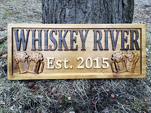 Wooden sign with 'Whiskey River Est. 2015' and beer mugs.