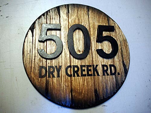 Round wooden sign with '505 Dry Creek Rd.' engraved.