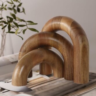 Three wooden arch-shaped decorative pieces on a table.