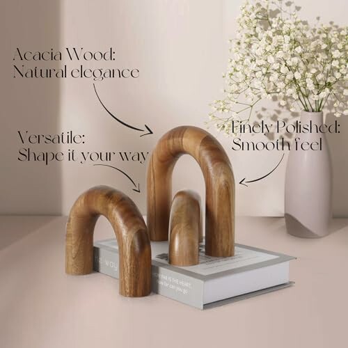 Wooden arches on books with flowers in vase.