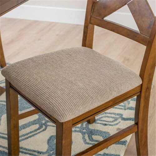 Wooden chair with upholstered seat on a patterned rug.