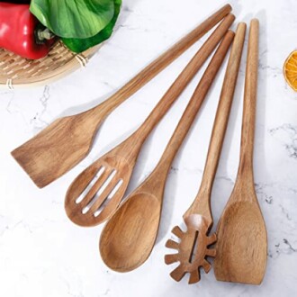 Set of wooden kitchen utensils on a marble surface.