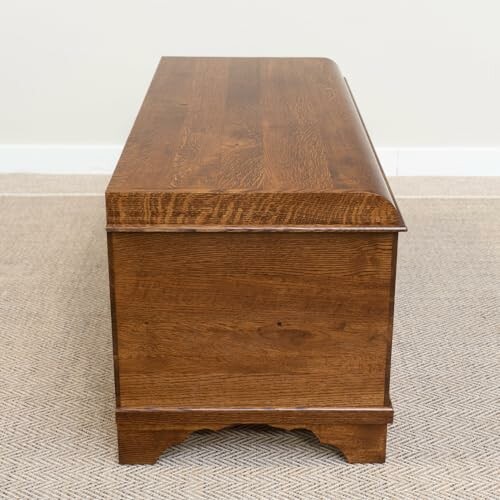 Side view of a wooden storage chest on carpet.