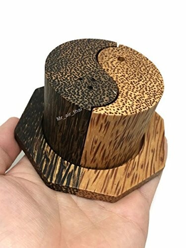 Yin yang wooden coasters held in hand